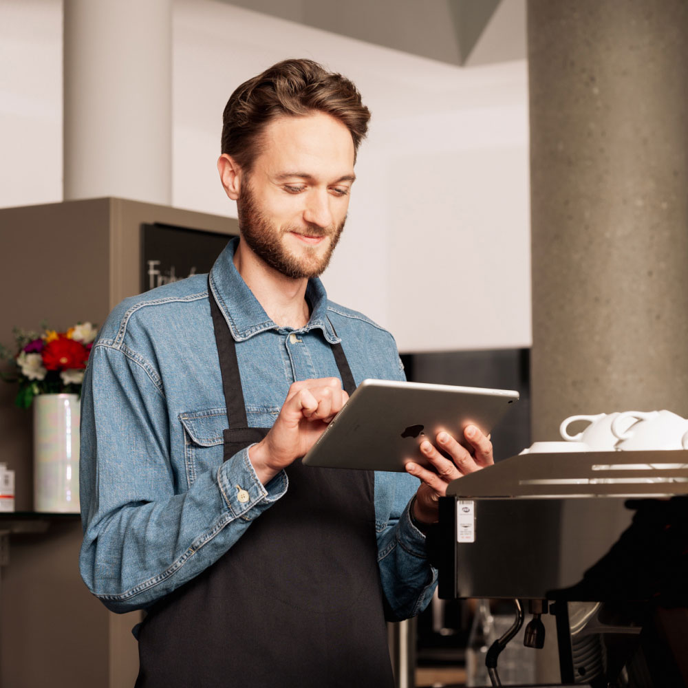 Man with tablet and apron in a restaurant