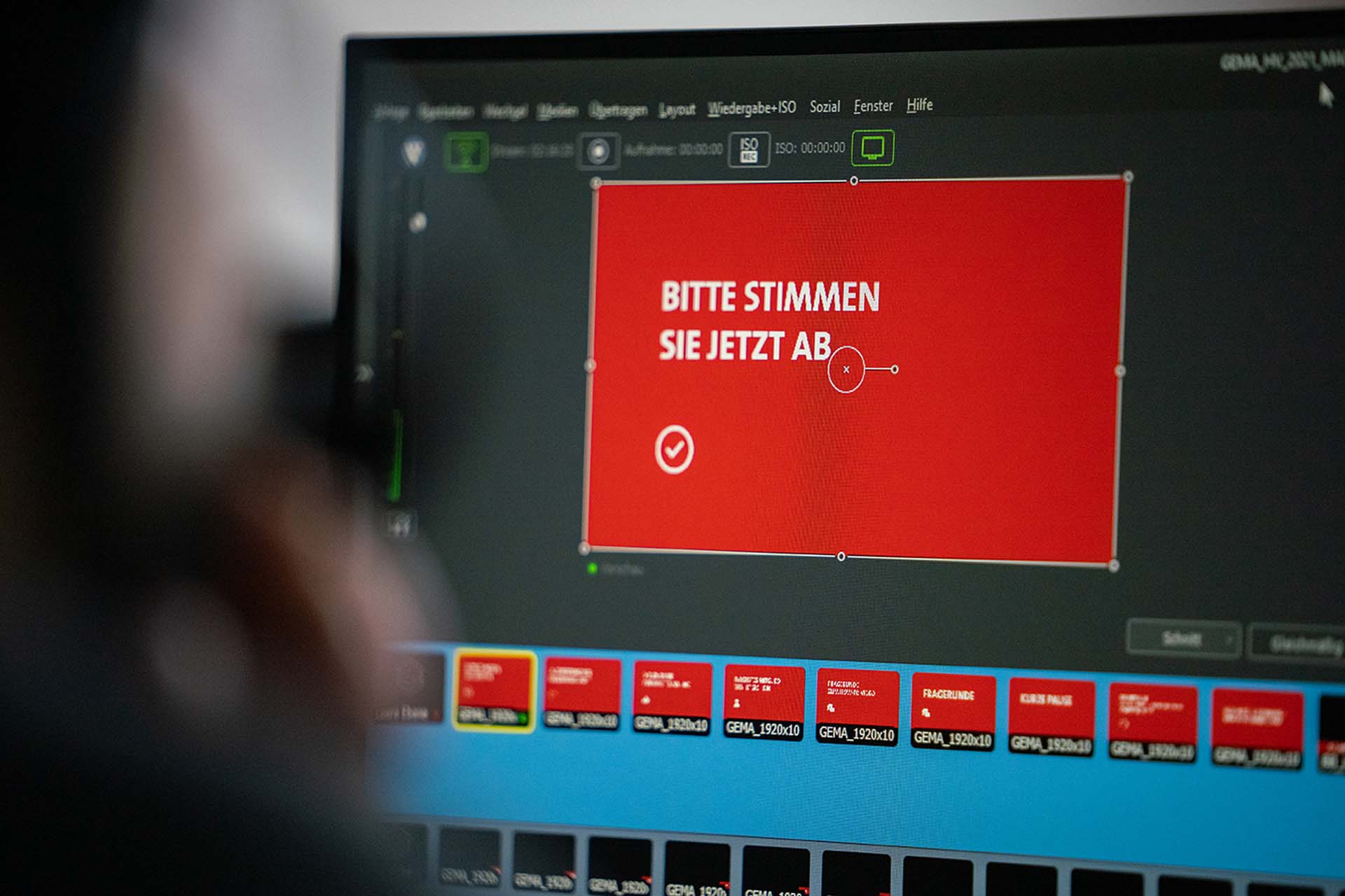 A computer screen displays a red box with German text and a checkmark icon, surrounded by various interface elements.