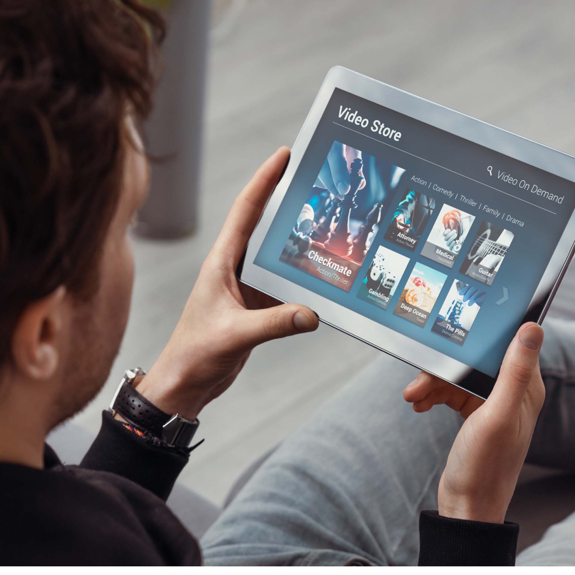 Eine Person hält ein Tablet mit einem Video-Store-Bildschirm, auf dem Filmoptionen angezeigt werden.