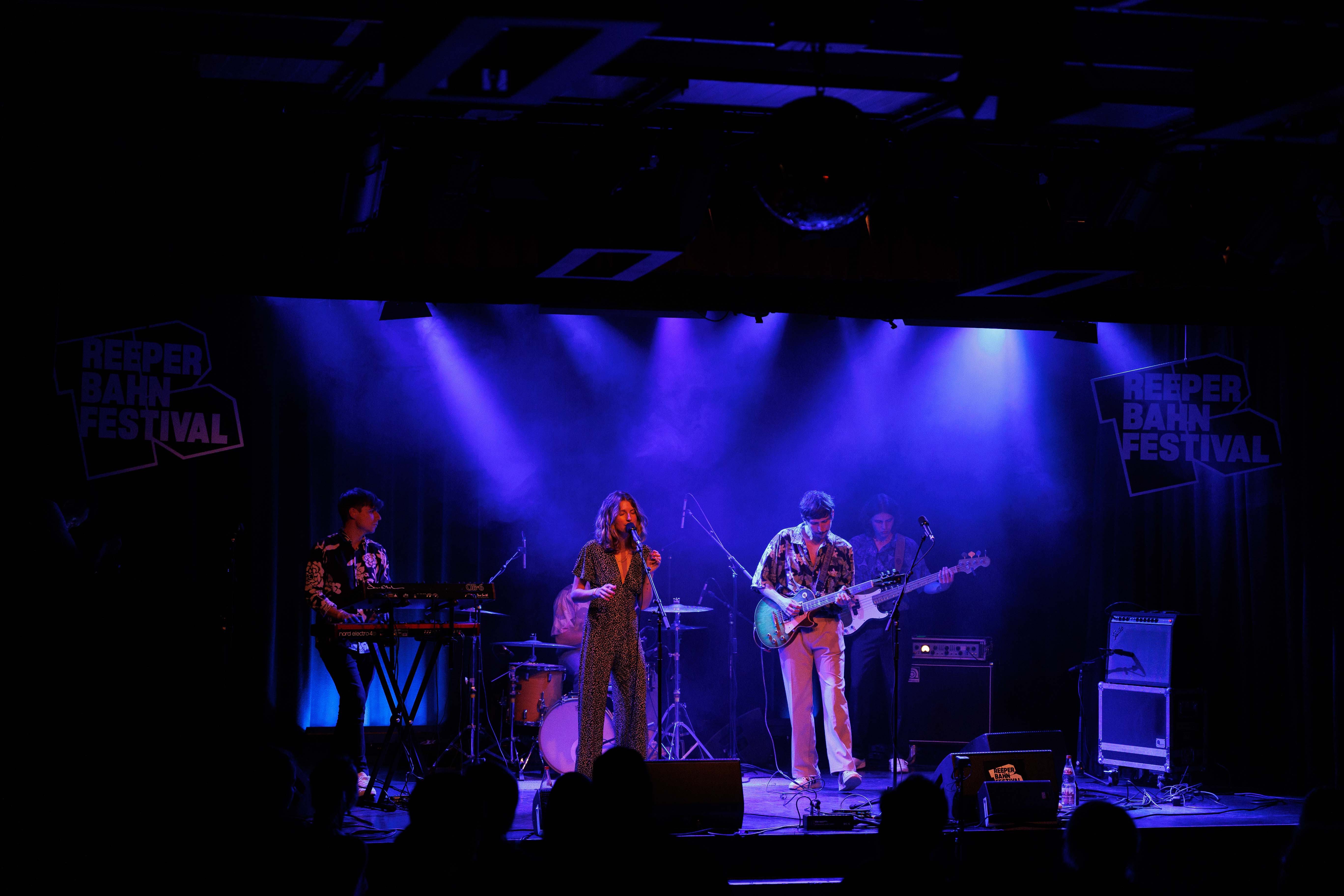 Eine Band spielt auf einer Bühne mit blauer Beleuchtung beim Reeperbahn Festival.